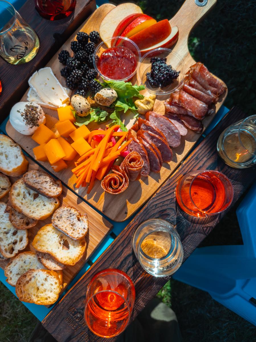 Table set with various meats, cheeses, and mead at Meadow Vista Honey Wines