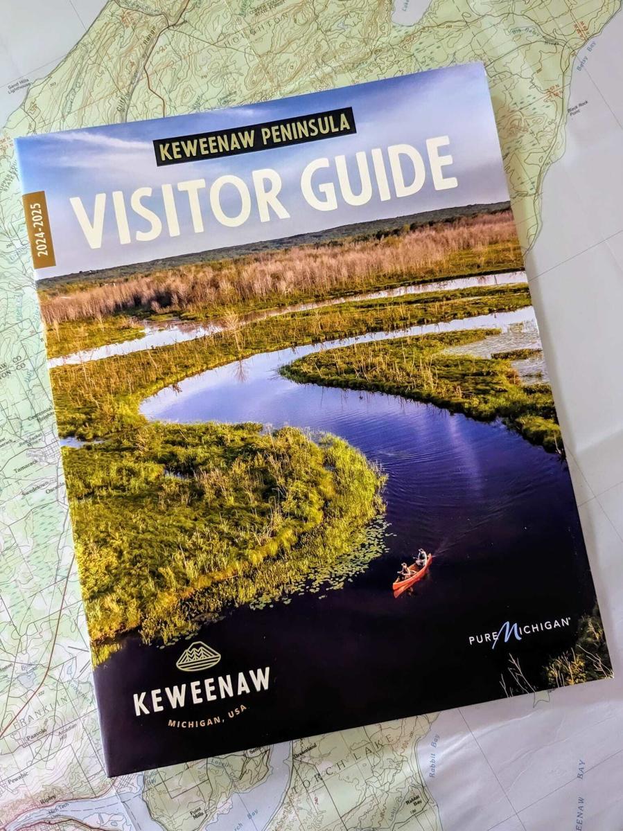 visitor guide sits on a map of the keweenaw peninsula