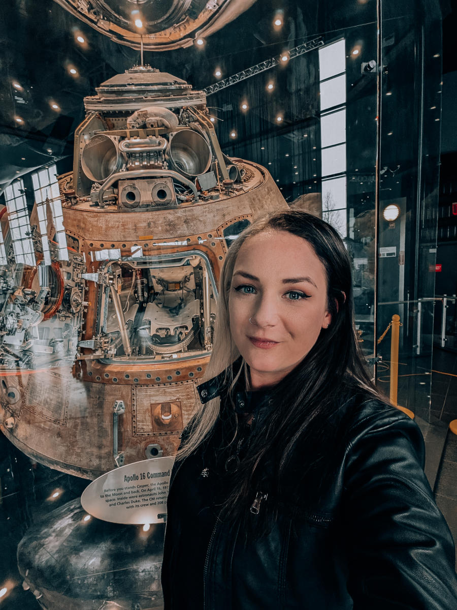 Phoenxy Powell takes a selfie in front of the Apollo 16 Command Module at the US Space and Rocket Center.