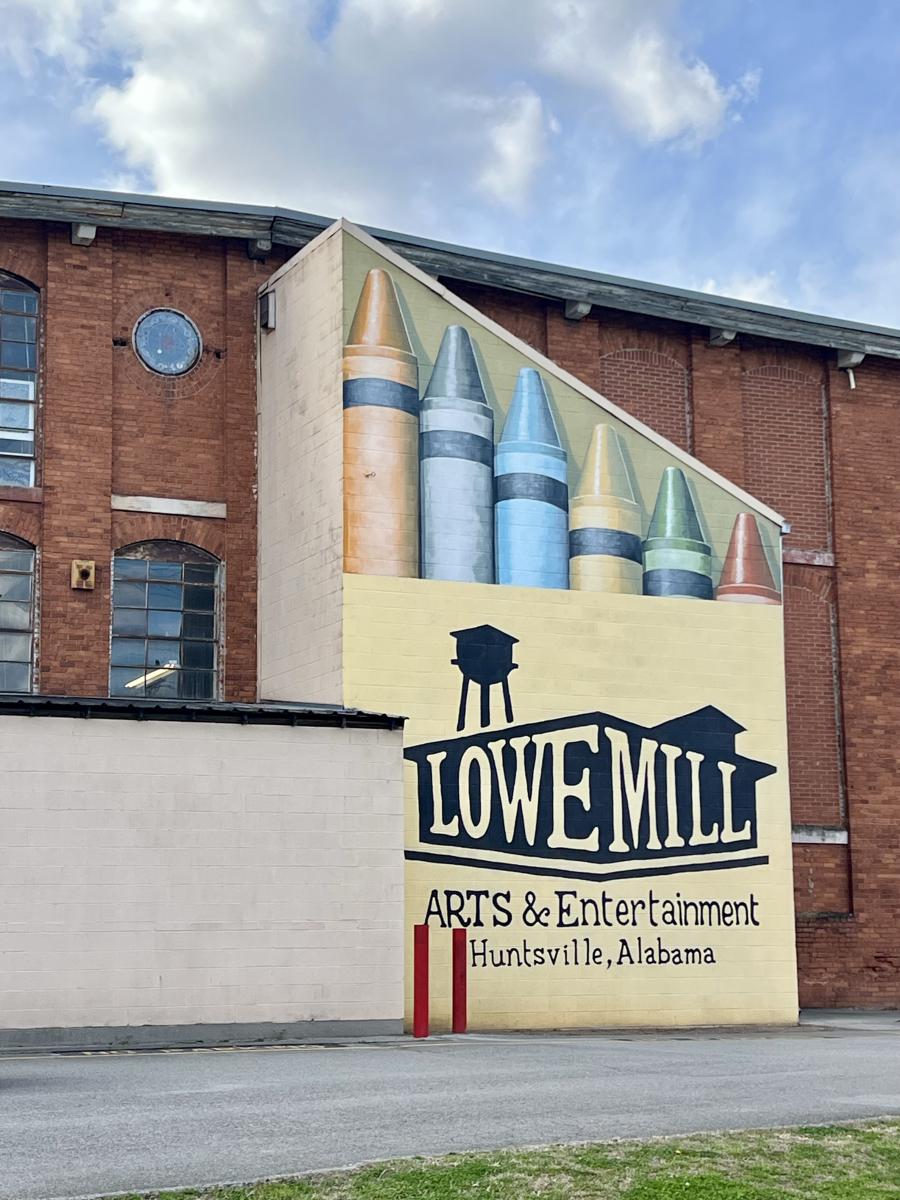 Large crayon box mural on a red brick wall at Lowe Mill Arts and Entertainment.