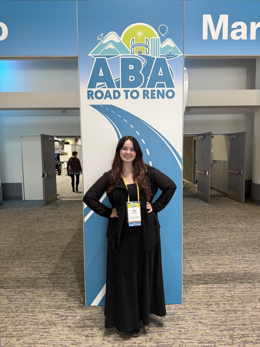 Meg Espie stands in front of a sign at ABA Marketplace.