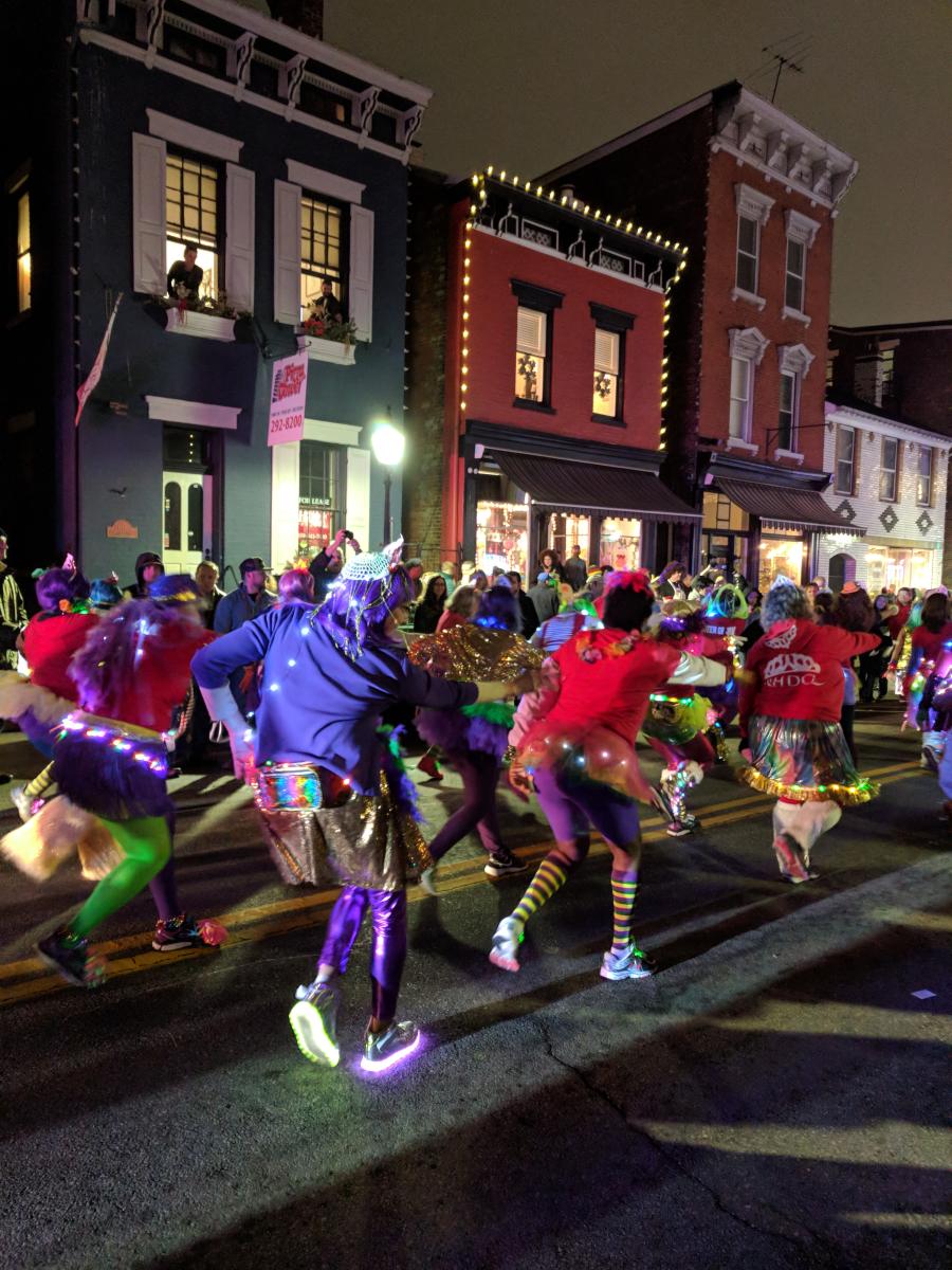 Image is of a Mardi Gras Parade going down Main Street in Mainstrasse.