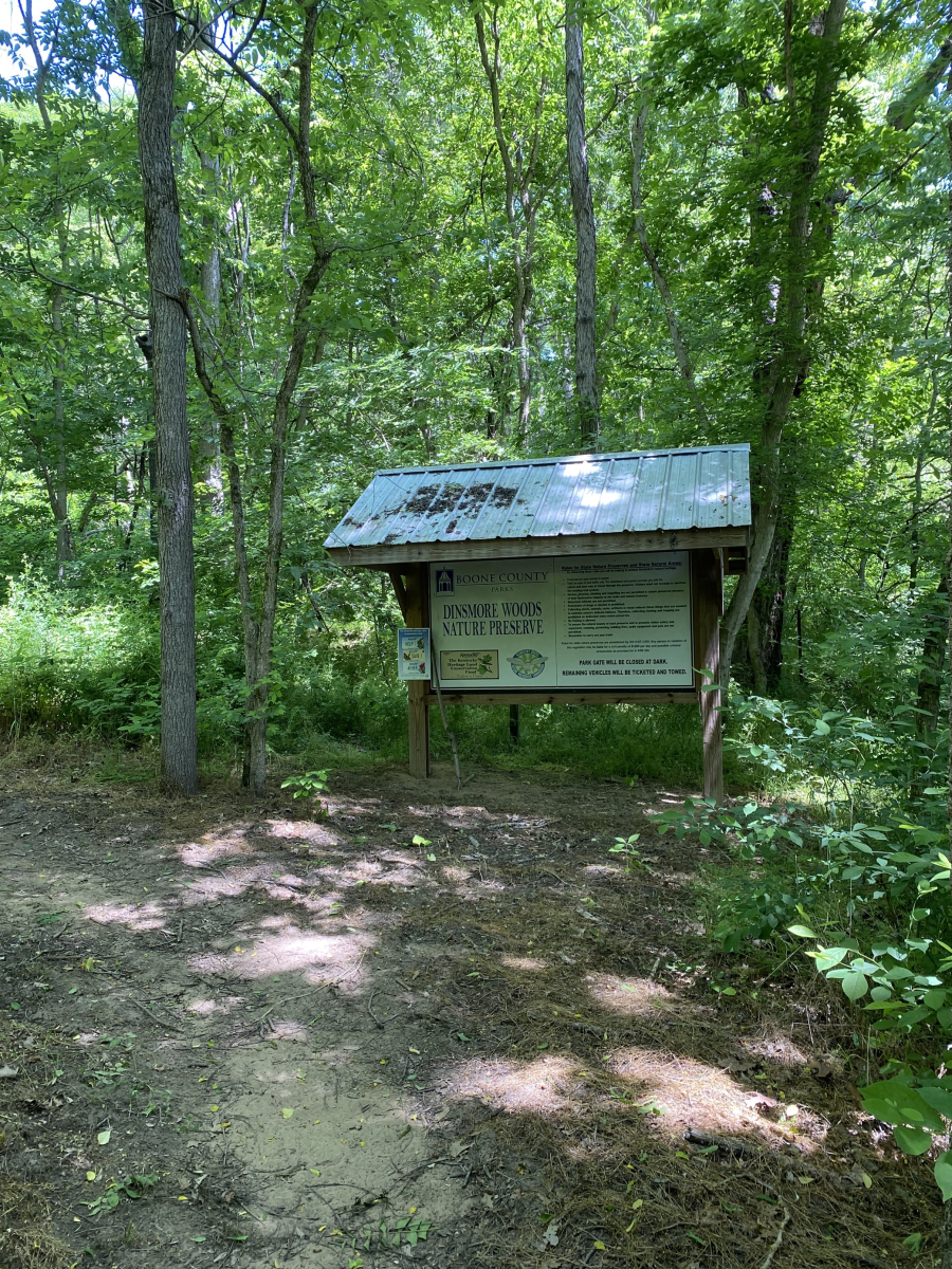 Image of the information board at the entrance of the Dinsmore Woods Nature Preserve surrounded by trees in bloom.