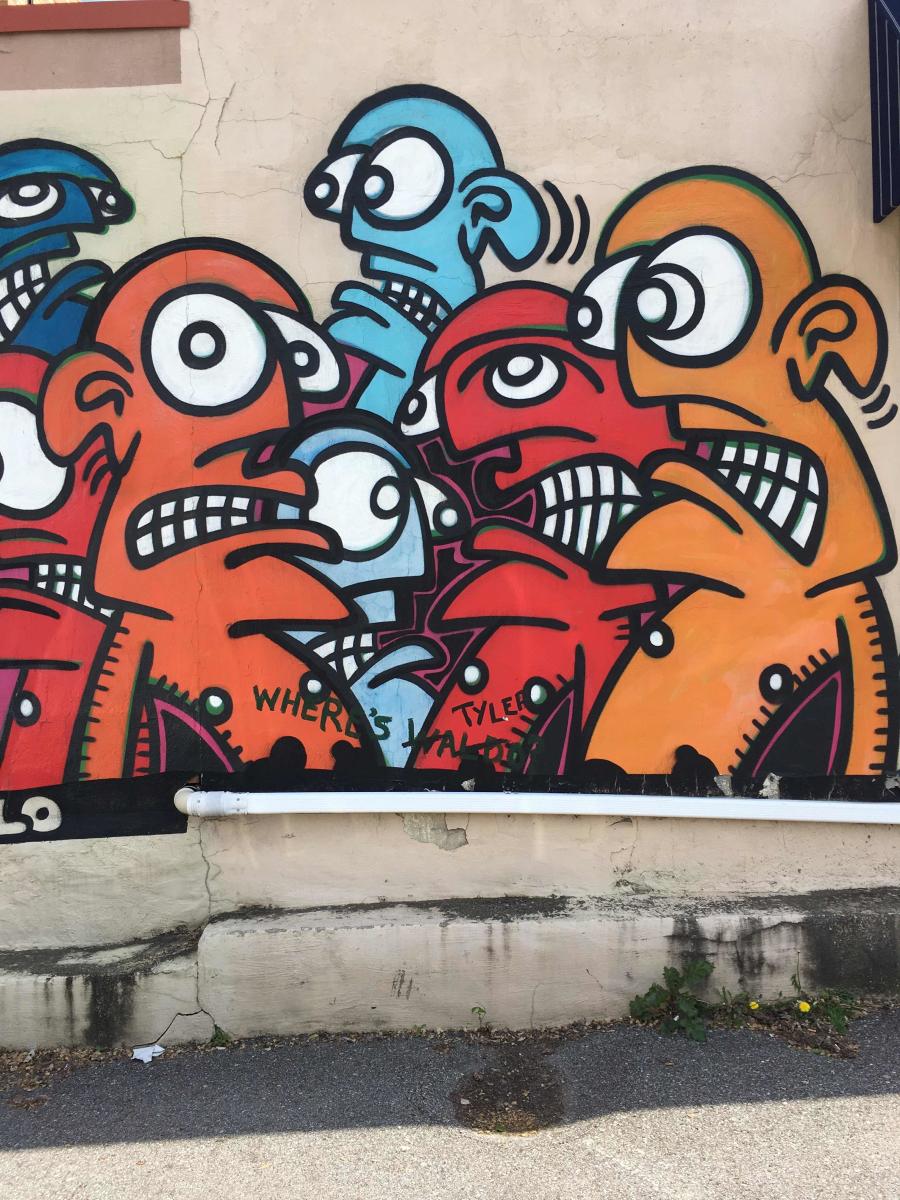 Orange, red, and blue faces in this street mural by the artist Galo, located in Covington, Ky.