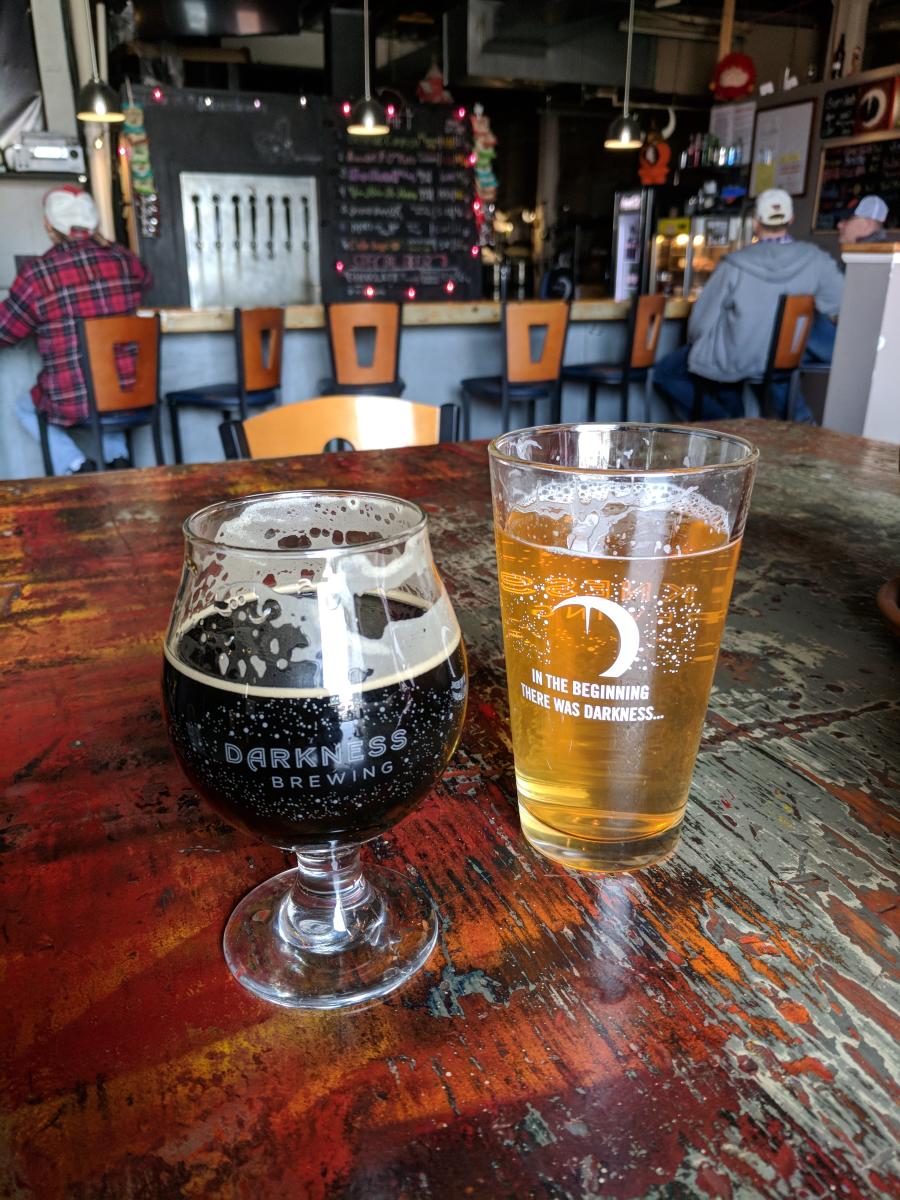 Two glasses of beer, one light one dark, on a wood table at Darkness Brewing in Bellevue Ky.