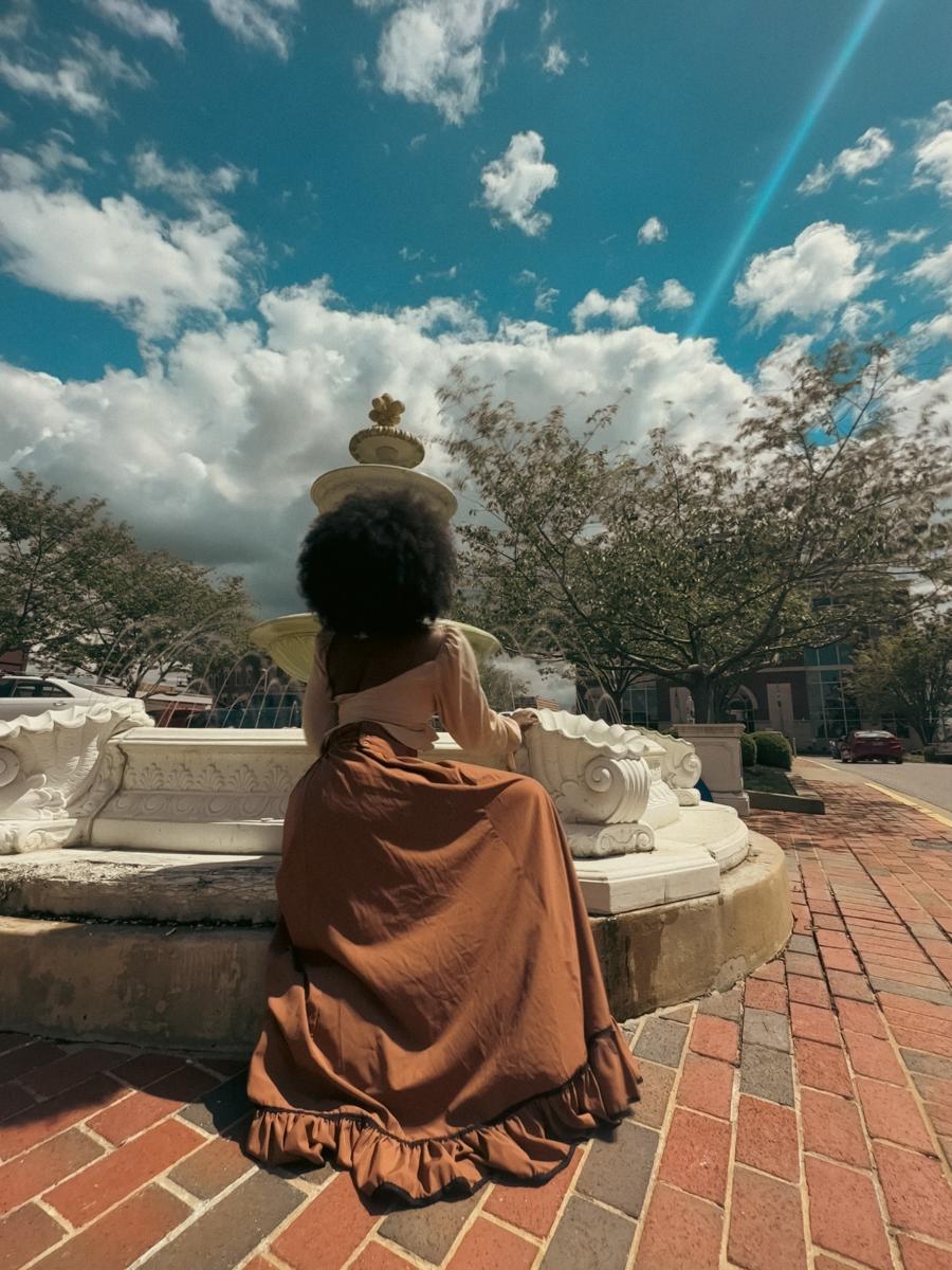 girls sitting by a fountain