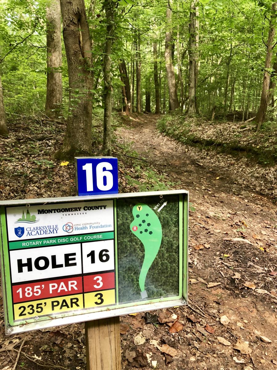 disc golf hole sign looking into the woods