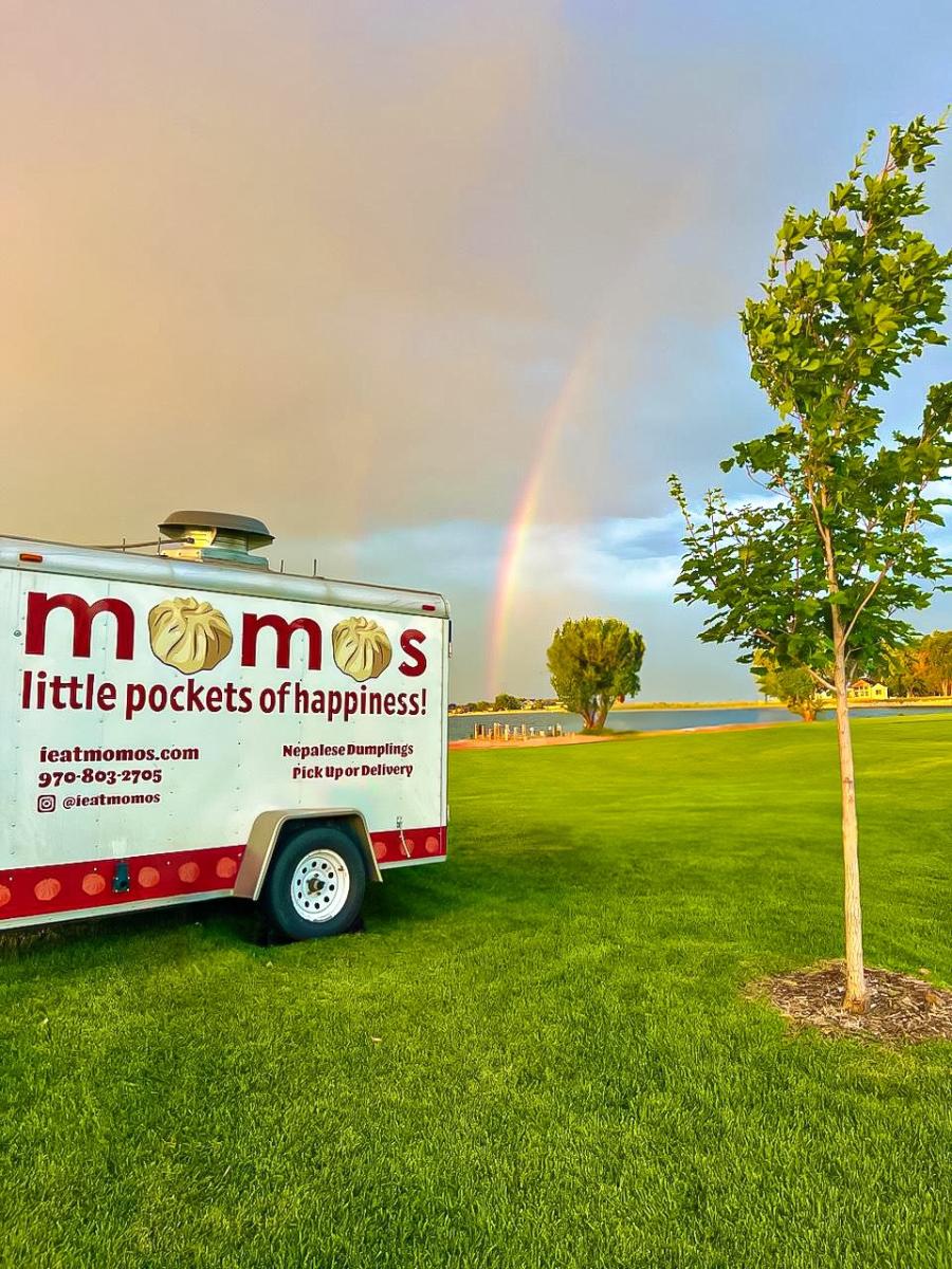 momos food trailer a park with rainbow