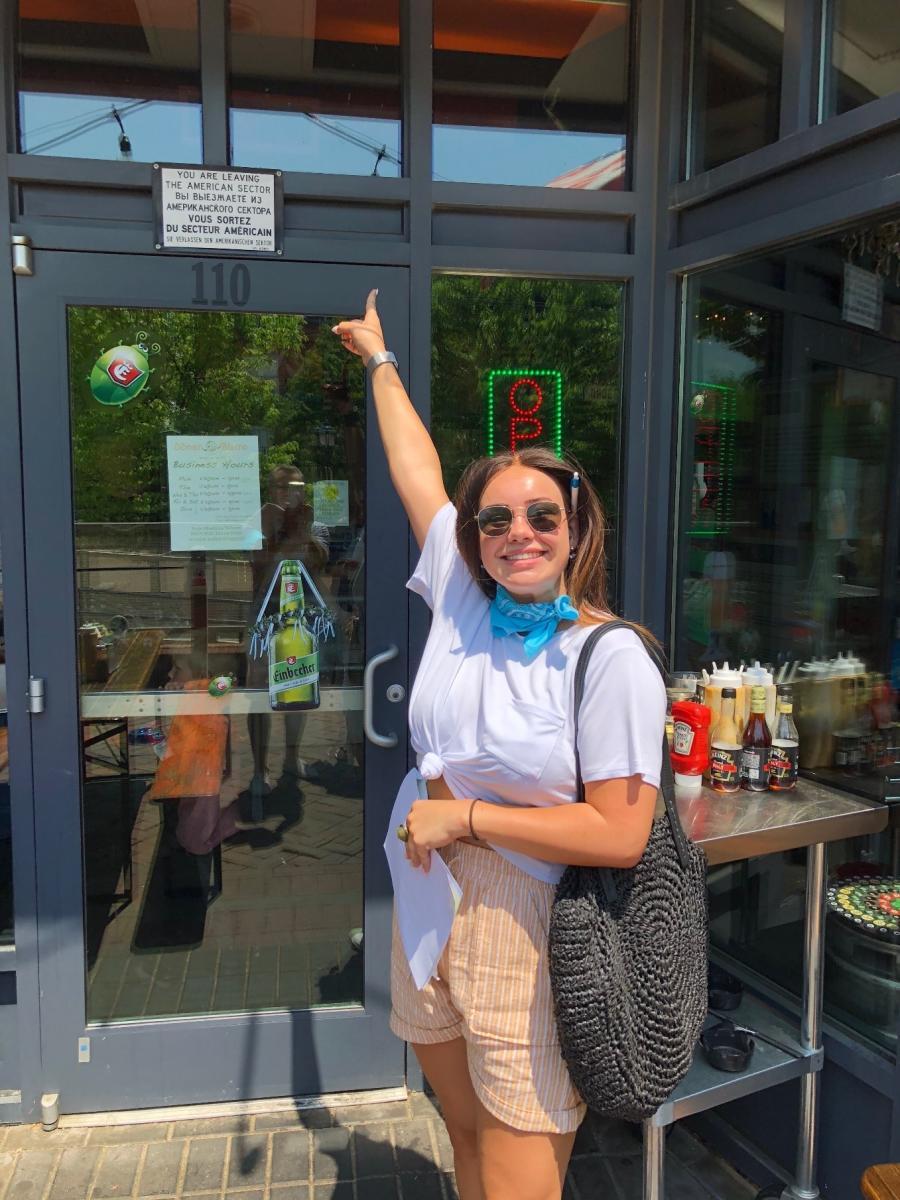 Woman pointing to the Doner Bistro sign