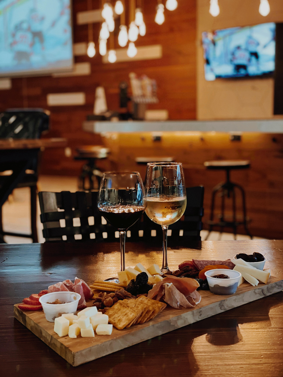 Charcuterie board with glasses at wine at Nosh & Bottle in Irving, TX