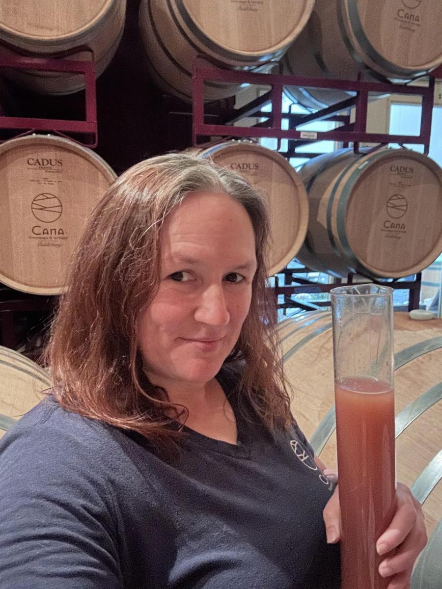Melanie Natoli of Cana Vineyards & Winery in Middleburg holding a rosé inside the barrel room
