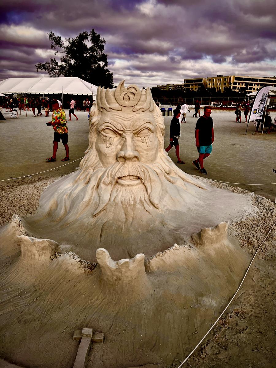 Sand sculpture of a wizard's head looking evil.