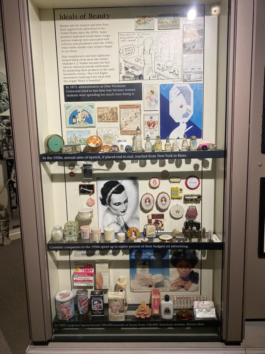 history of makeup over the years in a lit up display case