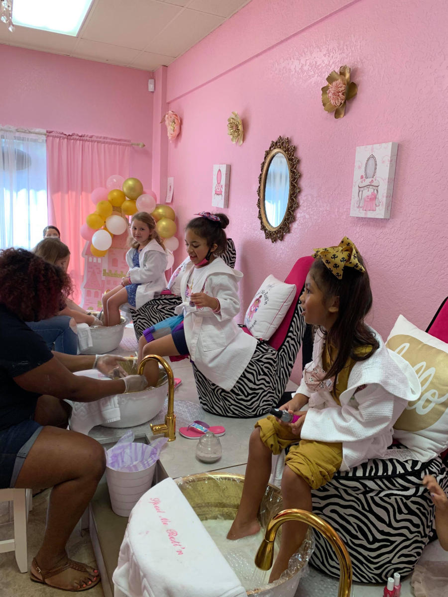 Young girls sit on fancy chairs as they get pedicures at Spoil Me Rott'n Day Spa for Kids, Slidell
