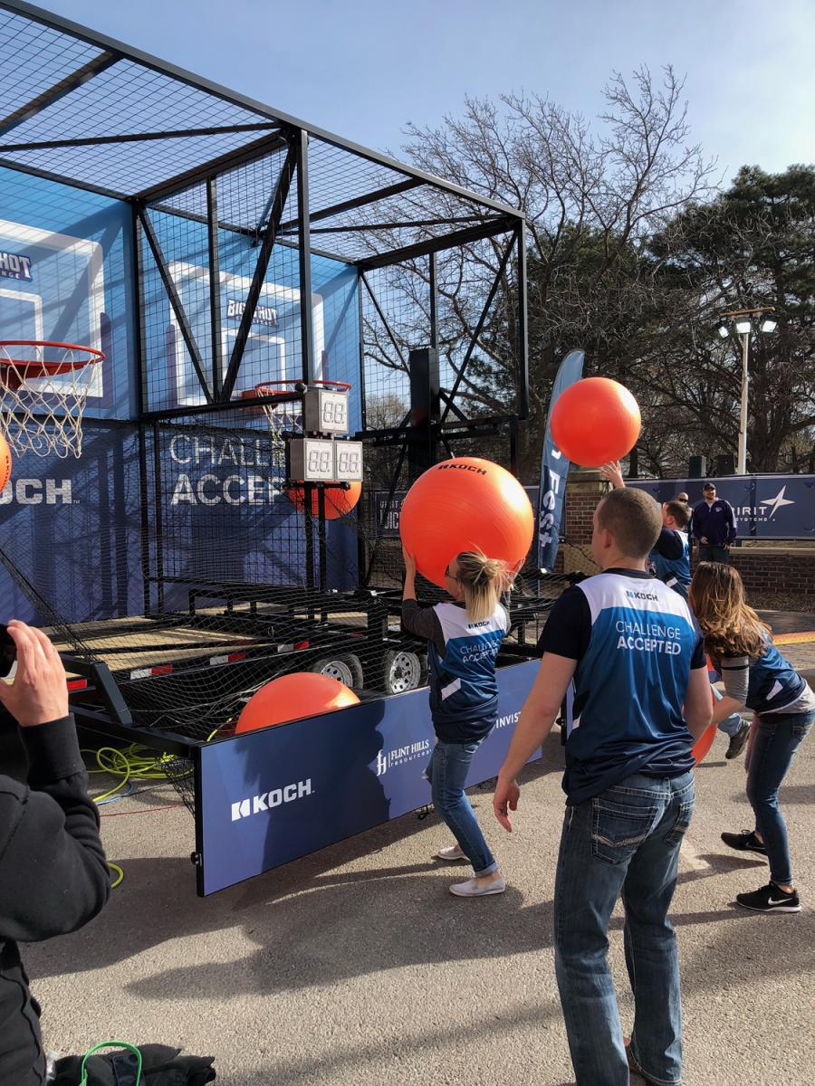 People shoot basketballs at a fan fest party during NCAA Men's basketball tournament