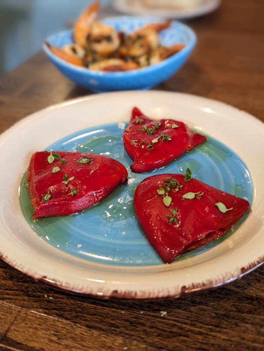 The image is 3 features piquillo peppers stuffed with goat cheese and olive oil drizzle.