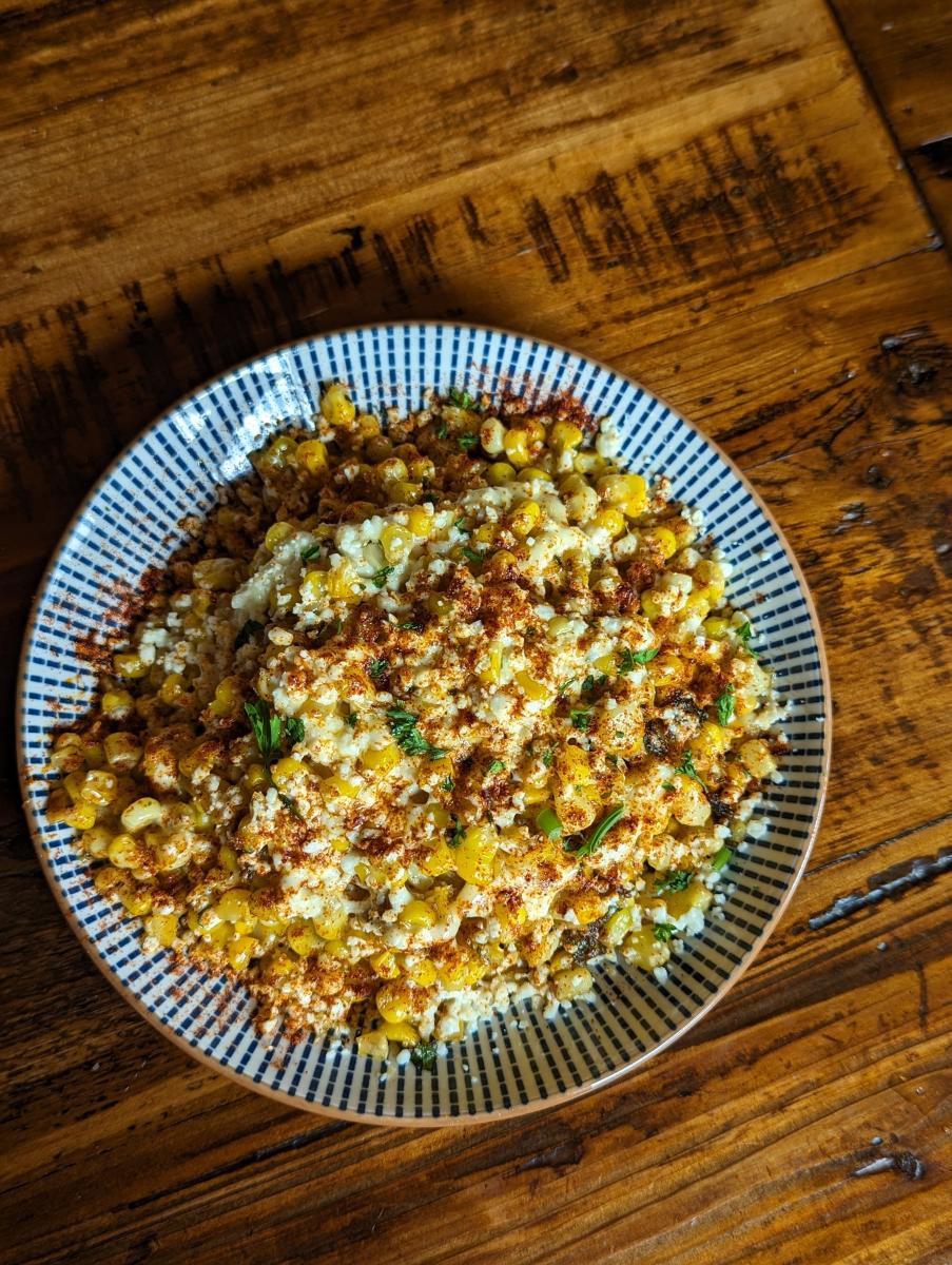 Image is of the Off Cob Elote at Shiners which is corn in a bowl with cheese, spices and peppers.