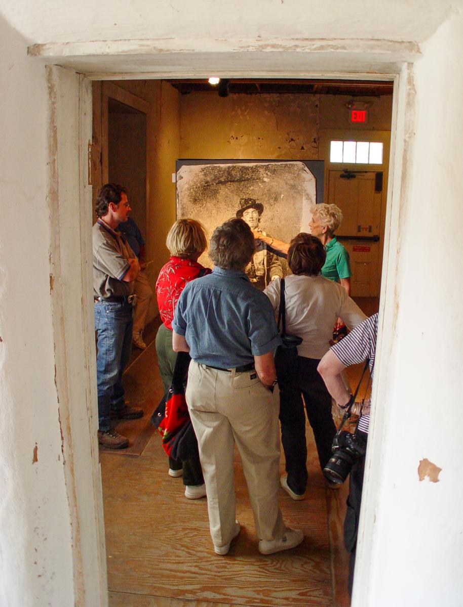 Group of people viewing a photo of Billy the Kid in the historic Lincoln County Courthouse