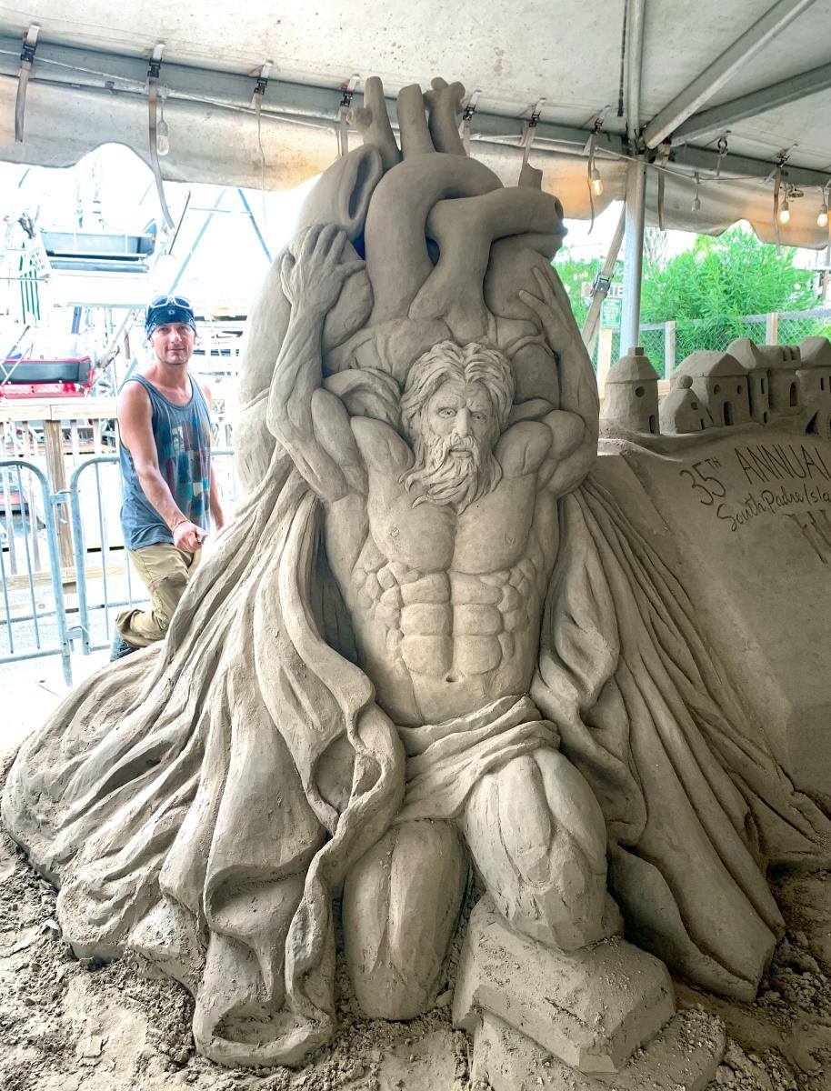 Sand sculpture showing a muscled atlas holding up a large burden