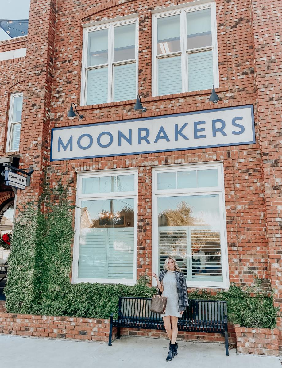 The Coastal Blonde poses in front of the Moonrakers front entrance in Beaufort, NC.