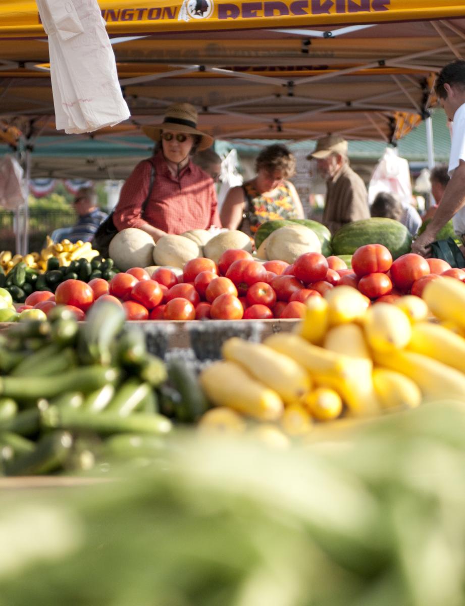 people shopping for fruits and vegetables at a farmers market