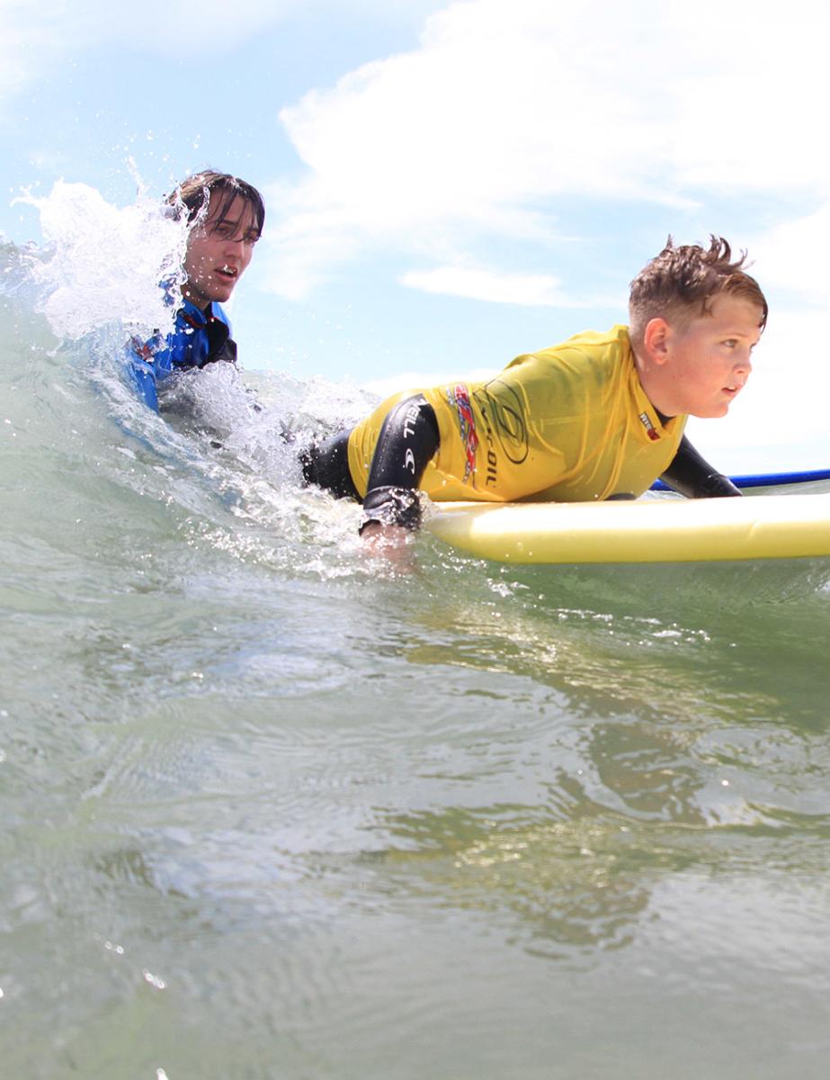 Boy learning to surf with 2XS