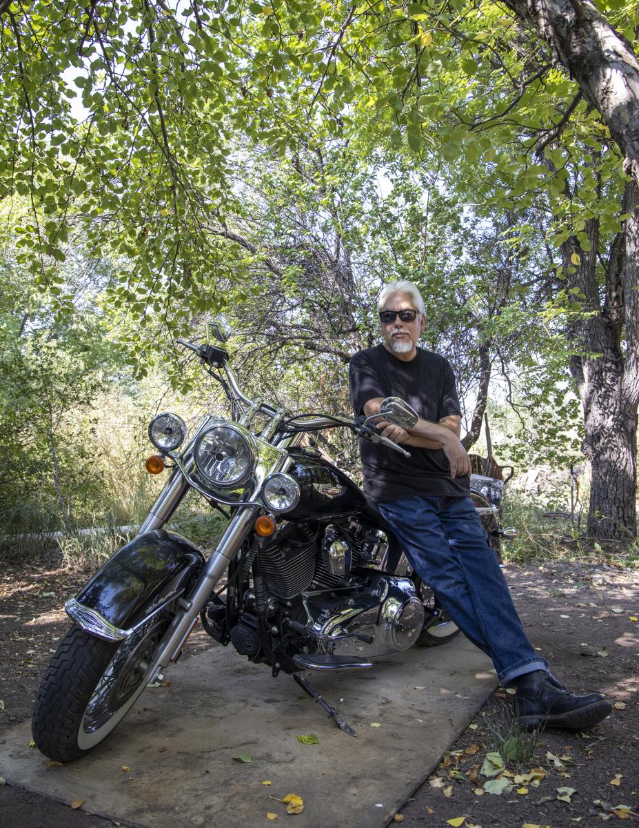 Levi Romero leaning against motorcycle