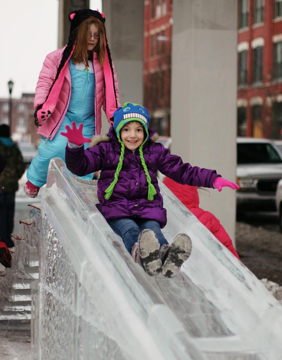 Girls going down a slide made of ice at the Richmond Meltdown