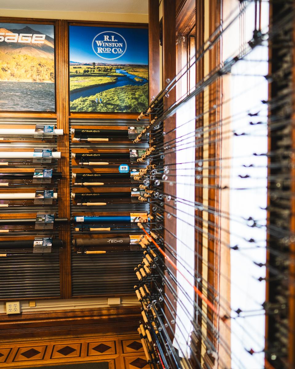 A photo of a fly fishing store's room with all of their fishing rods.