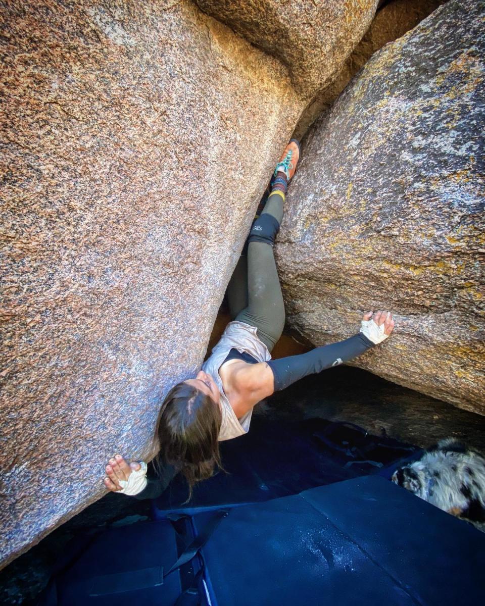 Climber working on a challenging bouldering route at Vedauwoo, one of the top bouldering spots in Wyoming, with crash pads below for safety.