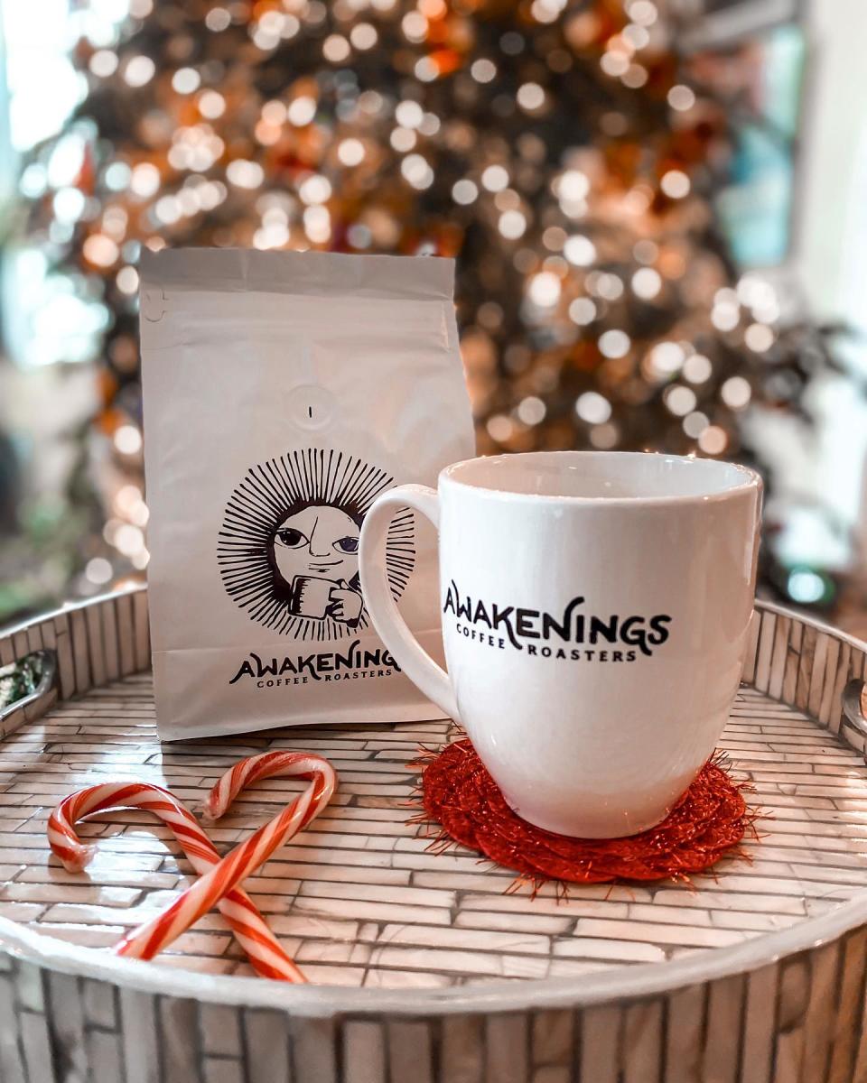 Coffee and mug in front of Christmas tree at Awakenings Coffee and Wine shop