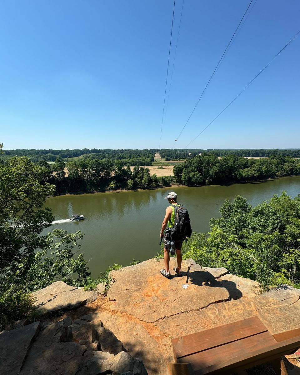 man on top of a bluff overlooking a river