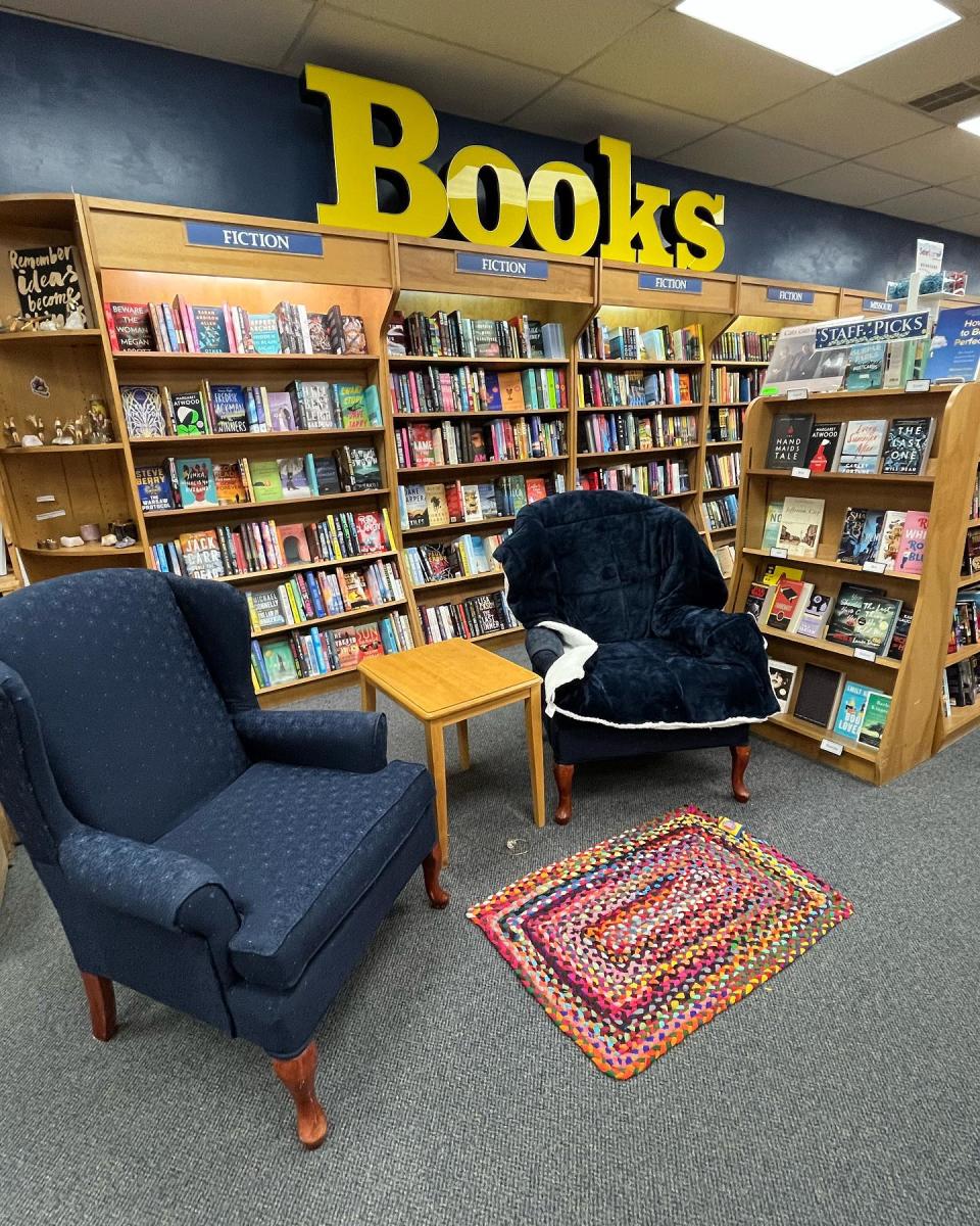 two armchairs in front of large bookcase with yellow "BOOKS" sign on top