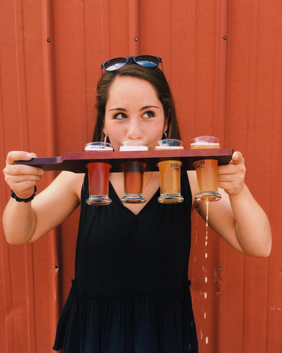Woman with beer flight at Quattro Goomba's Brewery