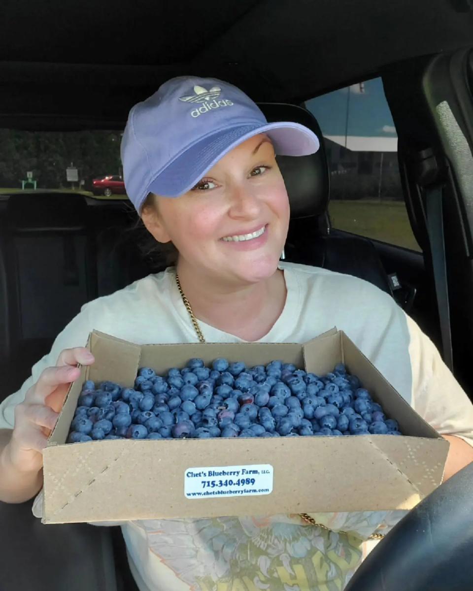 Woman holding box of blueberries