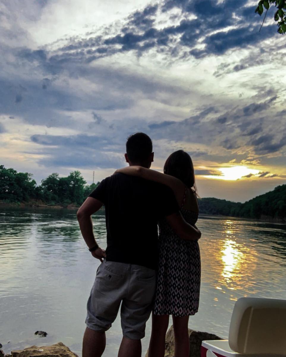couple by a river at sunset