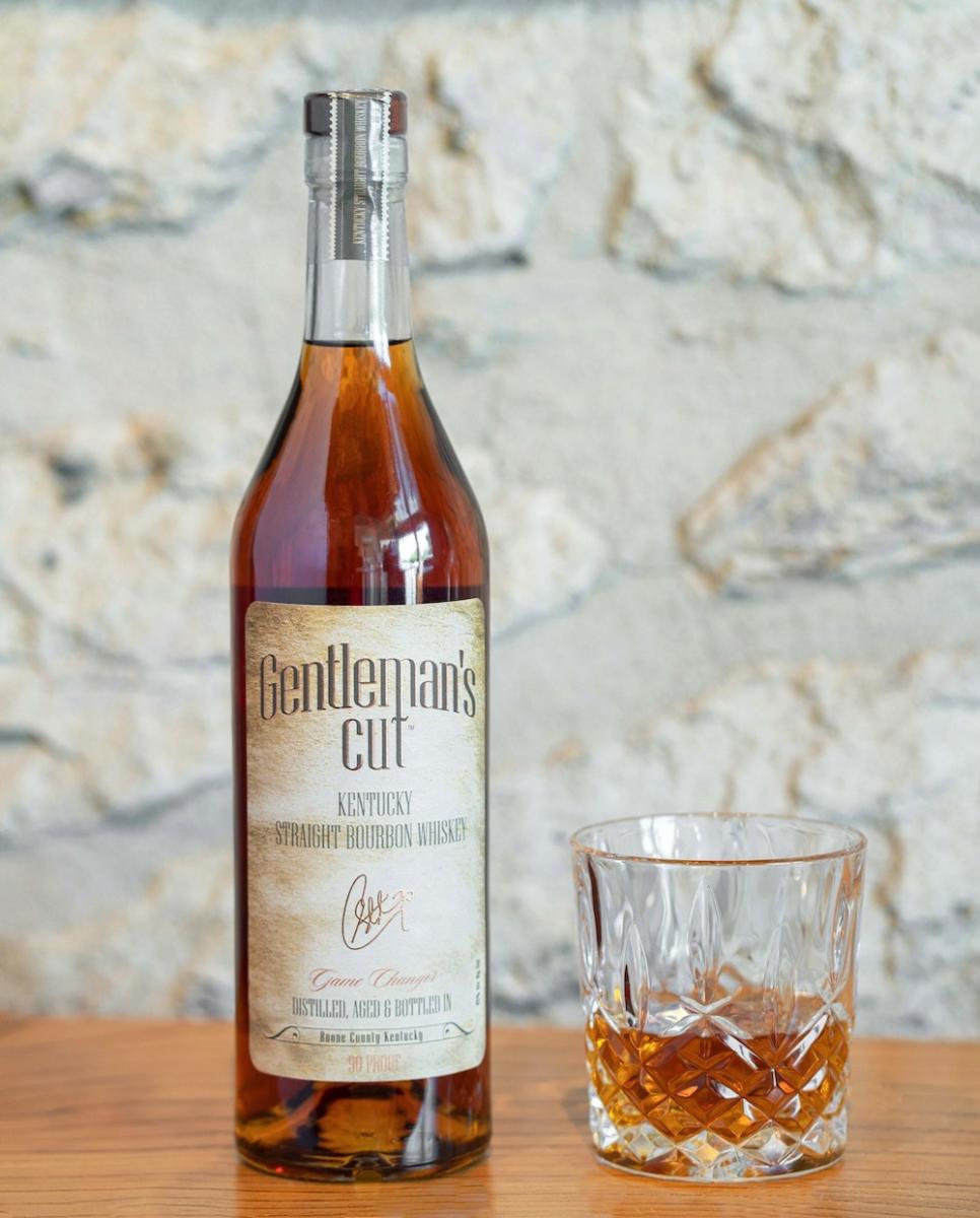 A bottle of NBA player Steph Curry's Gentleman's Cut bourbon sits next to a glass of the spirit