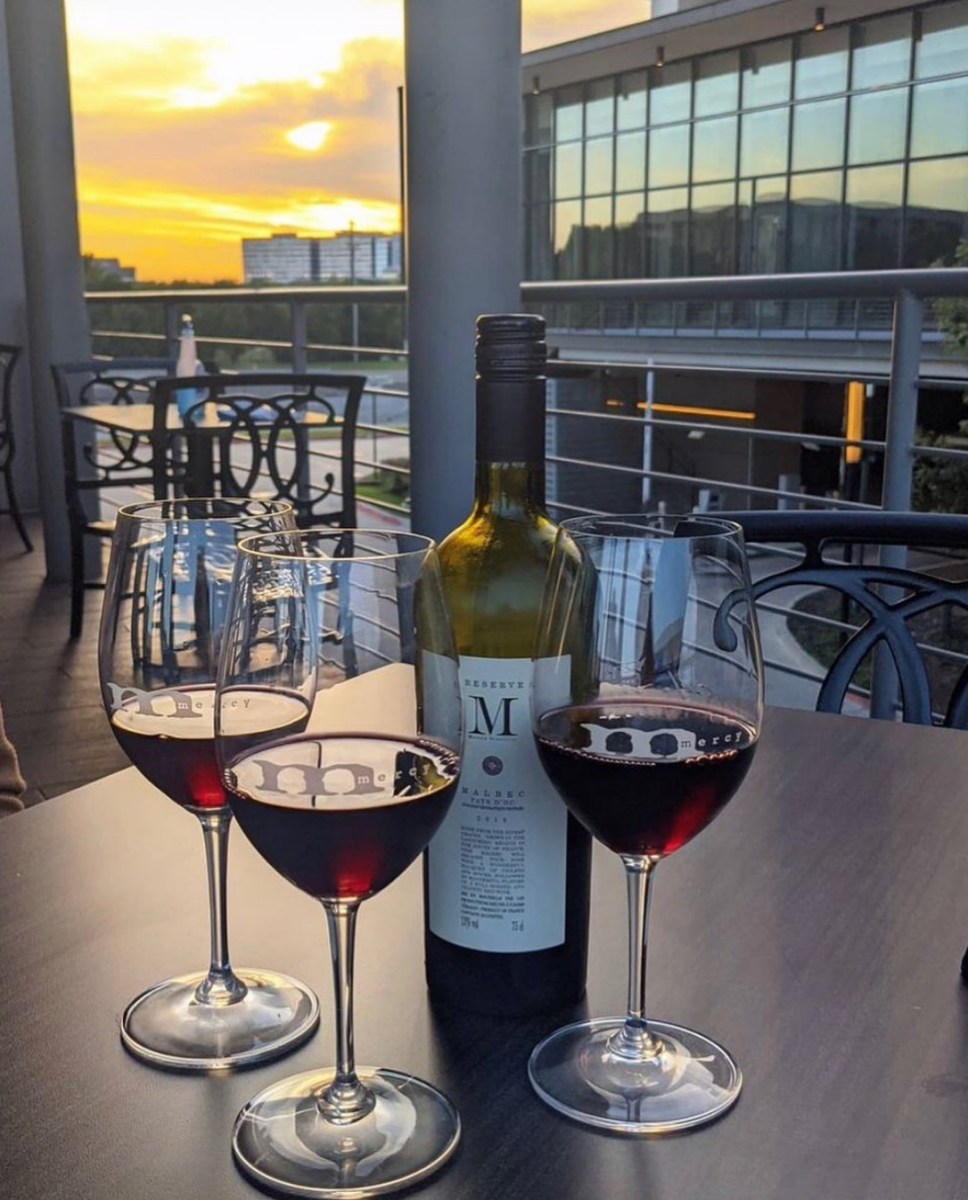 Wine Glasses On A Table With A Sunset At Mercy Bar & Lounge In Irving, TX