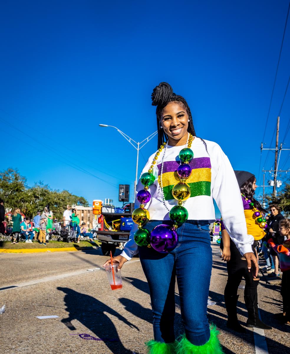 A young woman dresses in the purple, green and gold of Mardi Gras at the Krewe of Dionysus parade in Slidell.