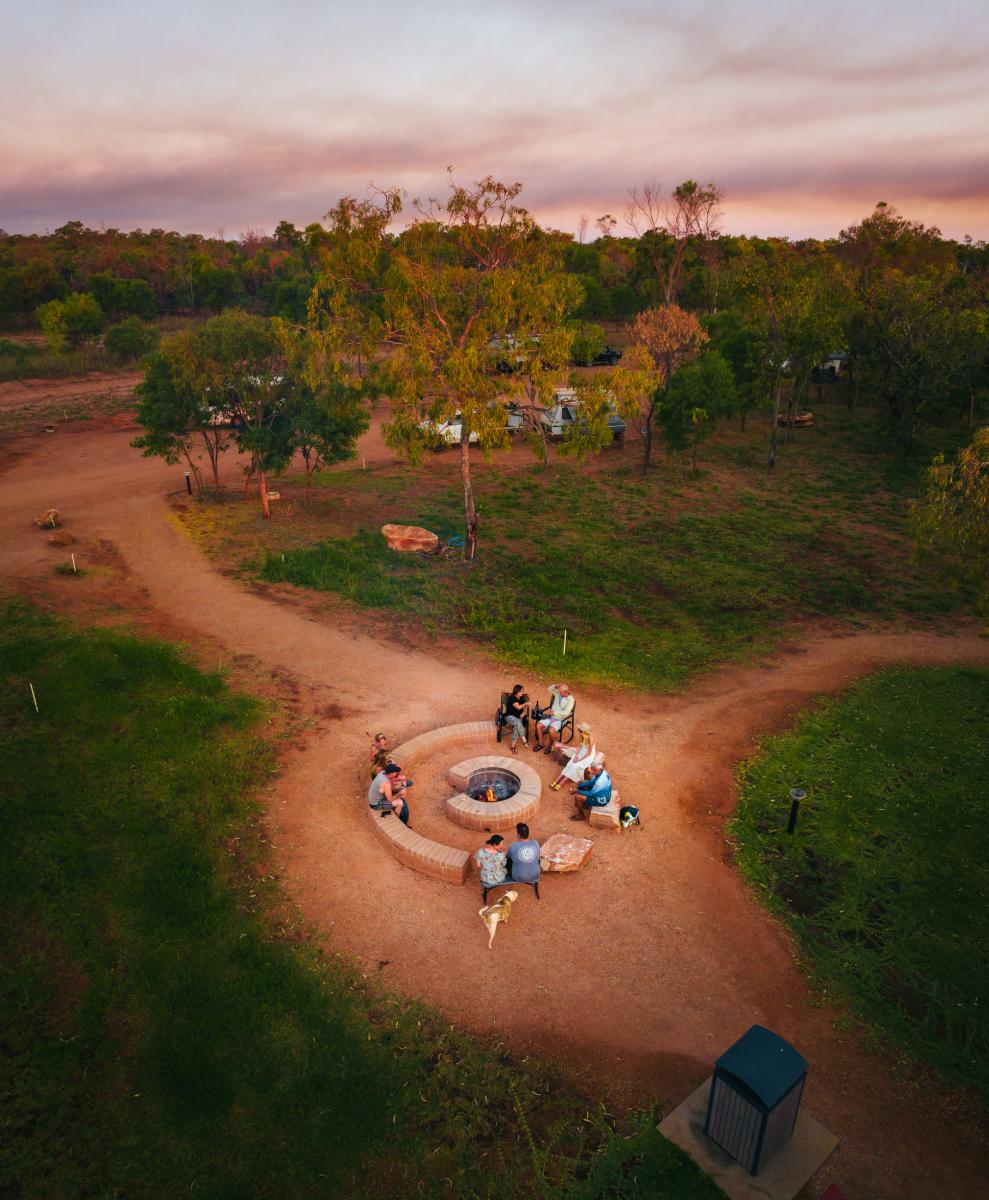 Campers sit around the fire pit area at Lombadina Campground at sunset