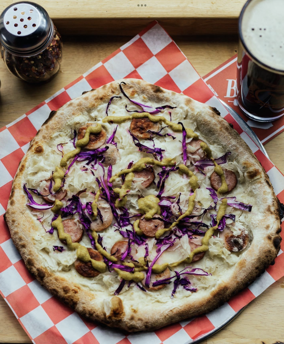 Image is of a pizza at Bircus Brewing Co. with a beer next to it.