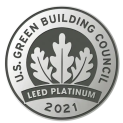 A silver medallion with gray text framing it that says U.S. Green Building Council. Three leaves sit in the center, with Leed Platinum, 2021, underneath.