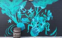 A black and blue mural by Anthony Wislar on the side of Creature Comforts Brewing