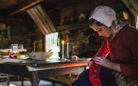 Young Lady sews a Revolutionary War-era coat in one of the historic cabins at Hickory Ridge.