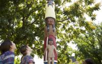 A group of children look up at the heritage pole at Mid-American All-Indian Musuem