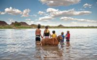 kids in river with dog