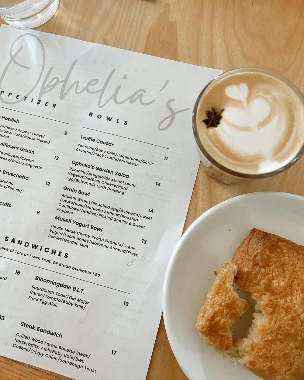 Ophelias menu, homemade biscuit, and fig cortado on a table