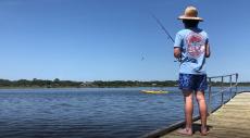 A man fishing off a pier at the Tomoka State Park near Daytona Beach