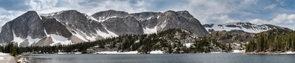 Snowy Mountains behind blue alpine lake