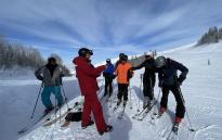 Group standing on their skis with guide of the Silver to Slopes tour.